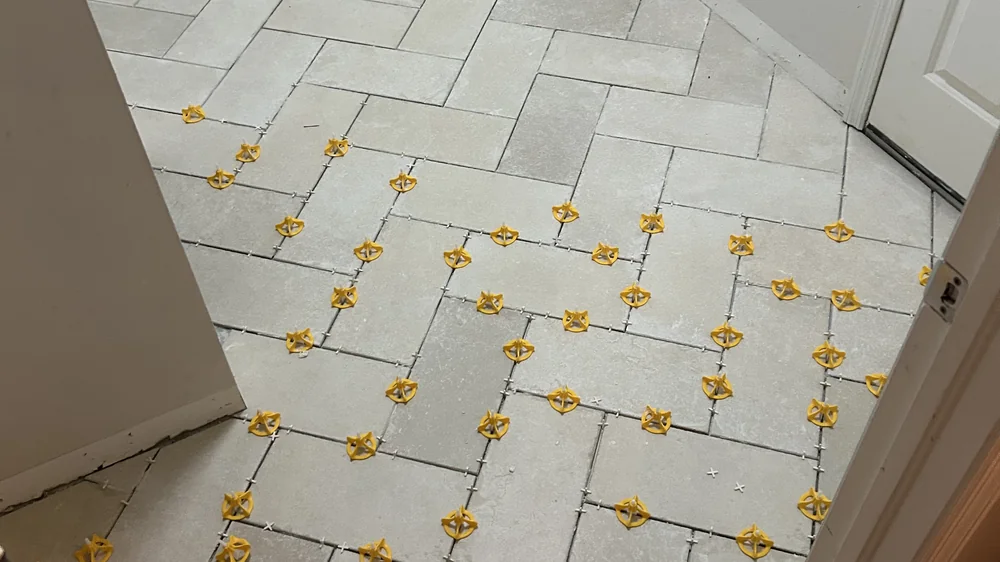 Crack isolation membrane being applied to a concrete slab before tile installation
