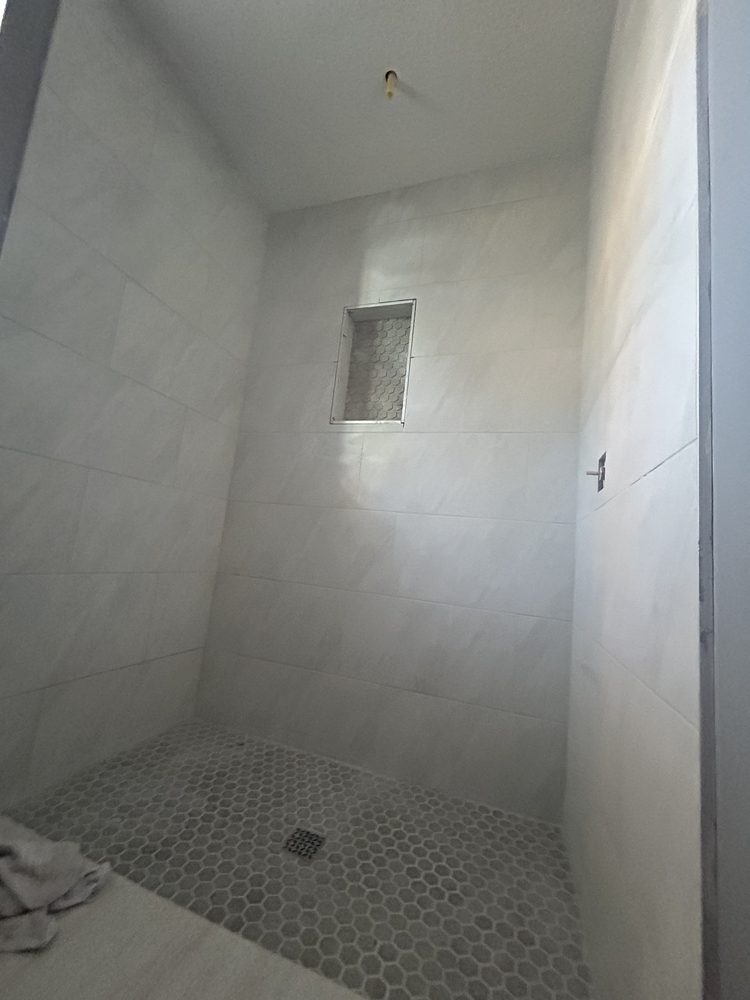 Large-format porcelain tile set on a bathroom wall in Pinellas County, Florida